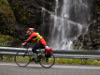 cyclist riding in front of a waterfall